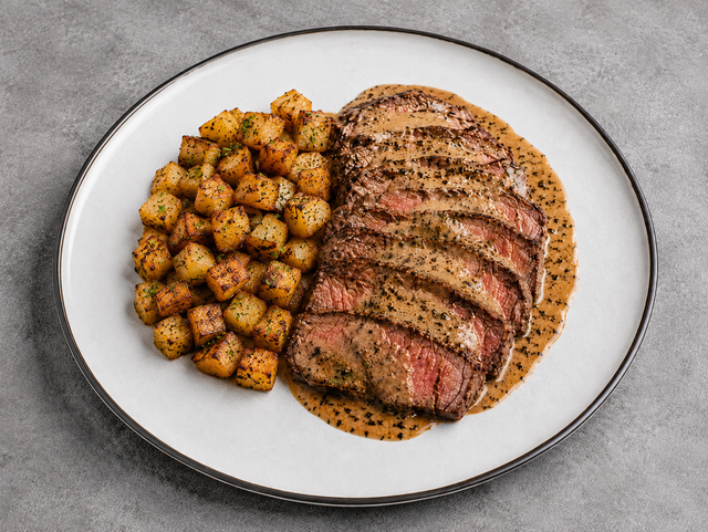 Pan-seared steak served with a creamy peppercorn sauce au poivre